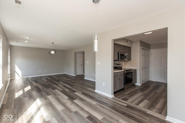 unfurnished living room featuring dark wood finished floors, baseboards, visible vents, and a textured ceiling