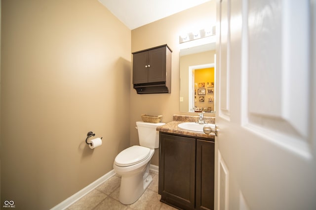 bathroom with baseboards, toilet, vanity, and tile patterned flooring