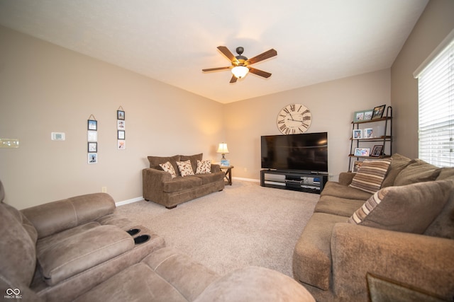 carpeted living room with baseboards and a ceiling fan