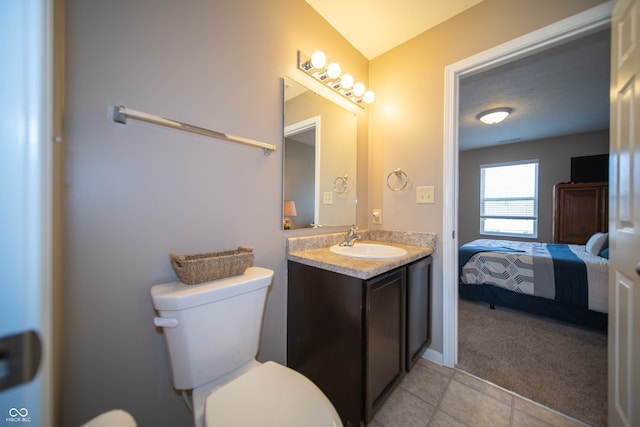 ensuite bathroom featuring tile patterned floors, ensuite bathroom, toilet, and vanity