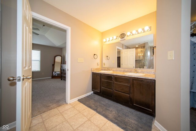 bathroom featuring double vanity, baseboards, a shower with door, and a sink