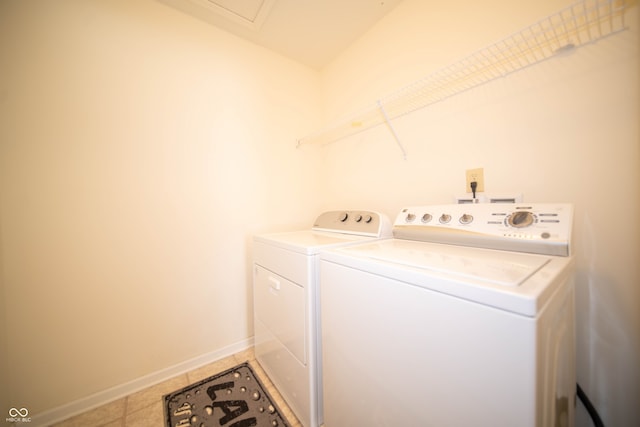 laundry area with tile patterned flooring, laundry area, separate washer and dryer, and baseboards