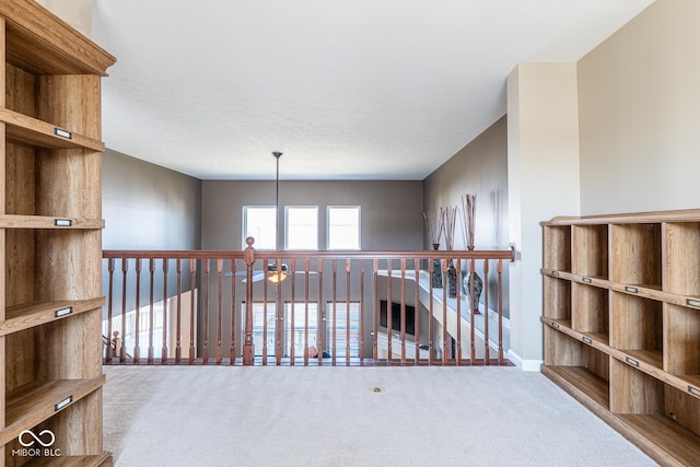 hallway featuring an upstairs landing and carpet floors