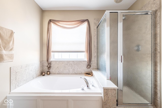 bathroom with a stall shower and a garden tub