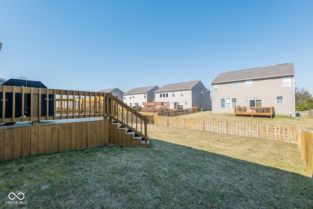 view of yard featuring a fenced backyard, a residential view, and a deck