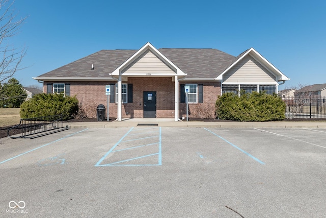 view of property with uncovered parking and fence