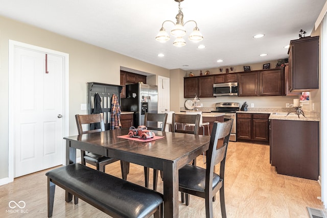 dining space with recessed lighting, light wood-style floors, visible vents, and a chandelier