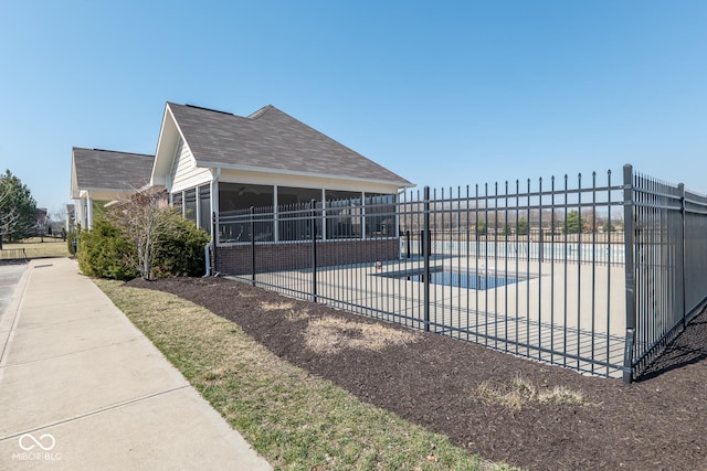 pool featuring a patio, fence, and a sunroom