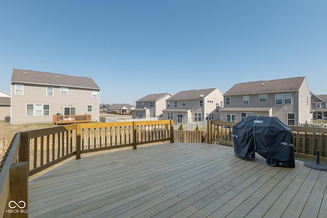 wooden terrace with a residential view and a grill