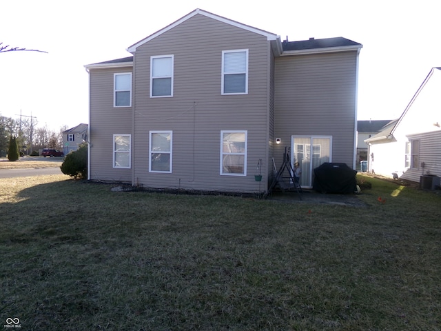 rear view of property featuring a lawn and central AC