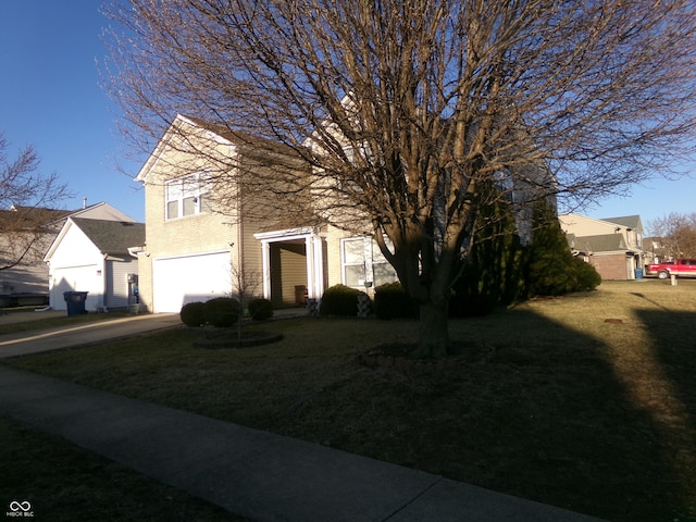 view of front of house with an attached garage, concrete driveway, and a front yard