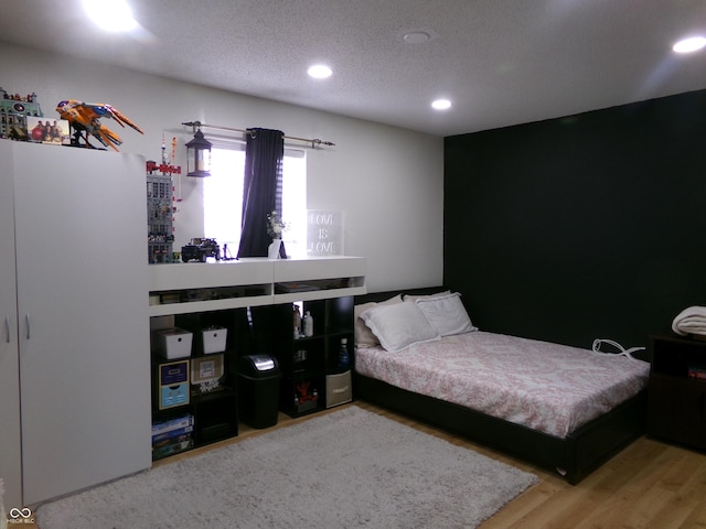 bedroom featuring recessed lighting, a textured ceiling, and wood finished floors