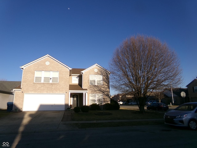 traditional-style house with a garage, brick siding, and concrete driveway