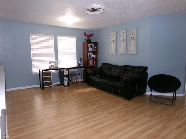 living room with wood finished floors, baseboards, and a textured ceiling