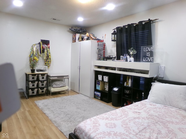 bedroom featuring visible vents and wood finished floors