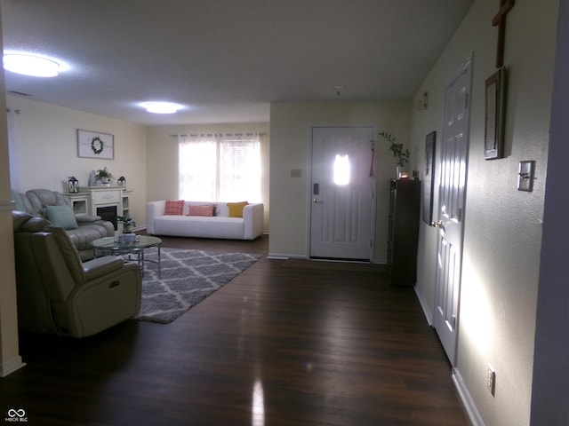 living area with baseboards and wood finished floors