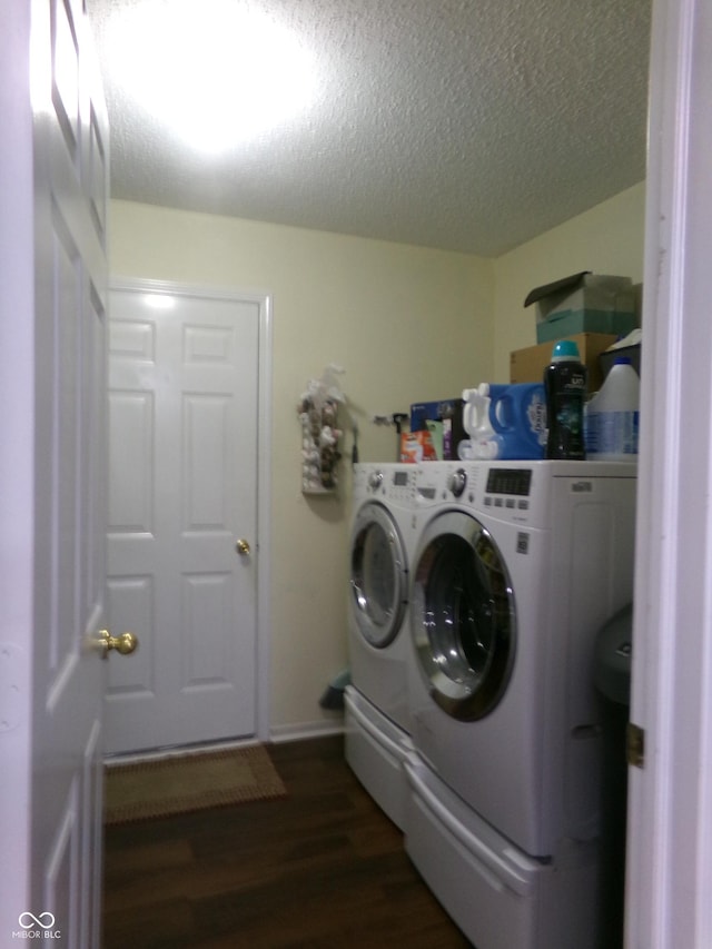 washroom with separate washer and dryer, dark wood-style floors, laundry area, and a textured ceiling