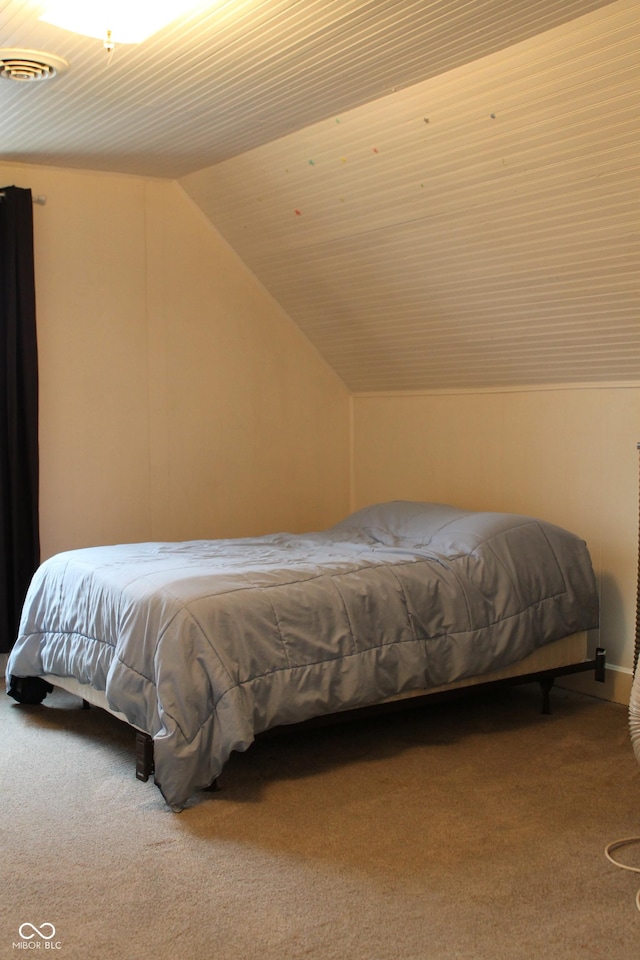 carpeted bedroom with lofted ceiling and visible vents