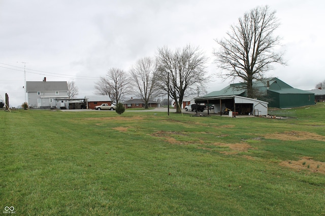 view of yard with a carport, an outbuilding, and a pole building