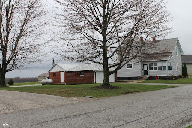 view of side of home featuring brick siding, a lawn, and entry steps