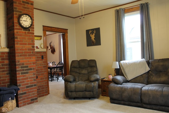 living area with carpet flooring, a ceiling fan, and ornamental molding