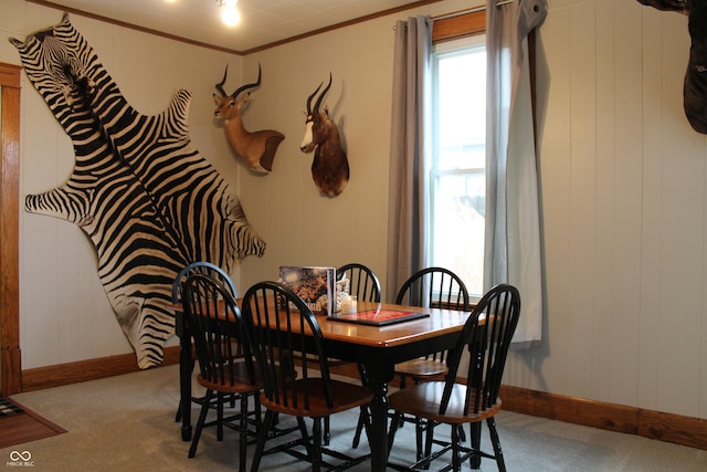 dining room featuring a wealth of natural light, carpet flooring, crown molding, and baseboards