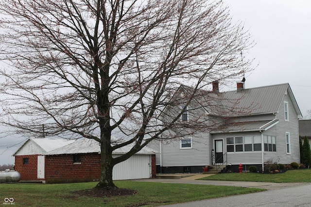 view of front facade with a front yard, a chimney, and entry steps