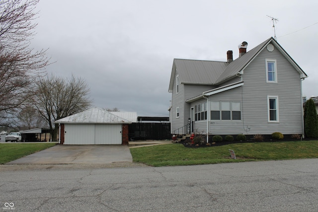 view of home's exterior with a yard, an outbuilding, metal roof, and a chimney