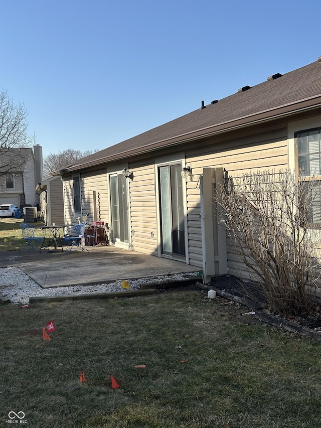 rear view of house with a patio area, central AC unit, and a lawn
