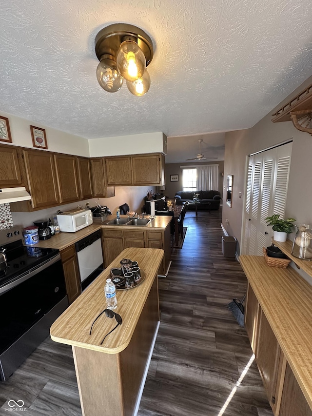 kitchen with under cabinet range hood, open floor plan, white appliances, ceiling fan, and dark wood-style flooring