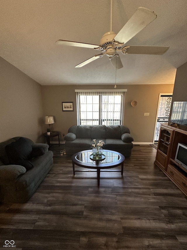 living room with lofted ceiling, a textured ceiling, dark wood-type flooring, and a ceiling fan