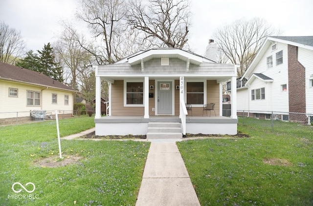 4504 Winthrop Ave, Indianapolis, IN 46205 - bungalow with fence, a chimney, covered porch, and a front yard