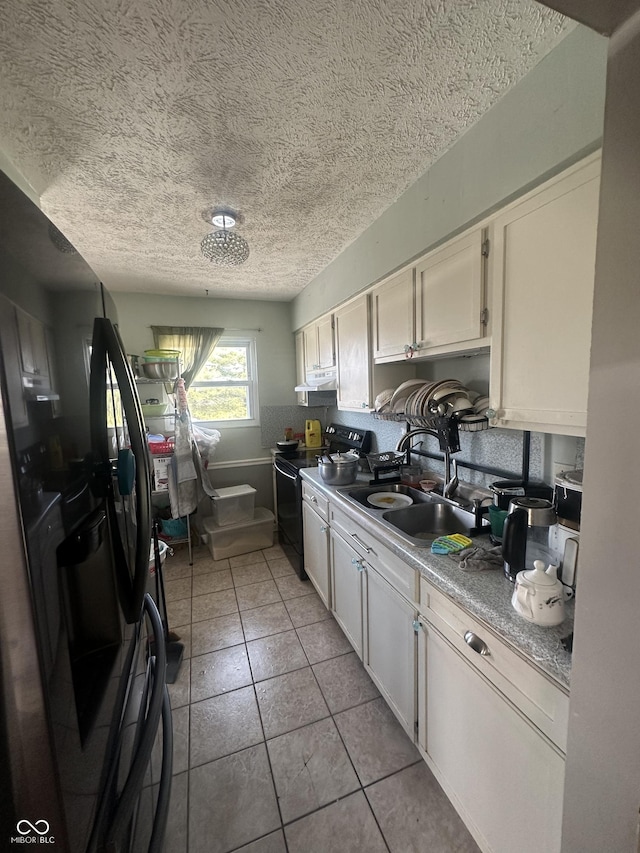 4930 Candy Spots Dr, Indianapolis, IN 46237 - kitchen with black appliances, a textured ceiling, light countertops, light tile patterned floors, and white cabinets