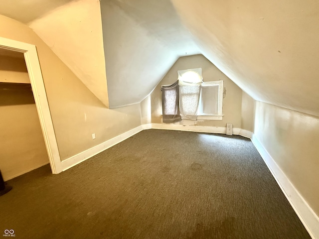 bonus room featuring vaulted ceiling, baseboards, and dark carpet