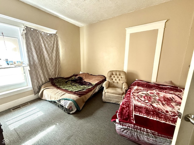 carpeted bedroom with visible vents and a textured ceiling