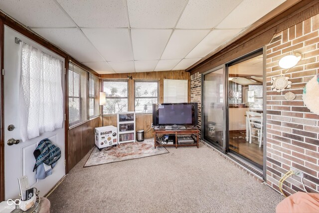 7152 Sandalwood Dr, Avon, IN 46123 - carpeted living room with wood walls, a drop ceiling, and brick wall