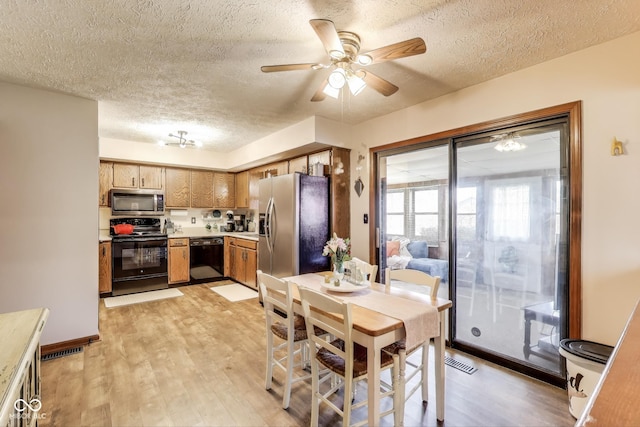 7152 Sandalwood Dr, Avon, IN 46123 - dining space featuring a textured ceiling, ceiling fan, visible vents, and light wood-type flooring