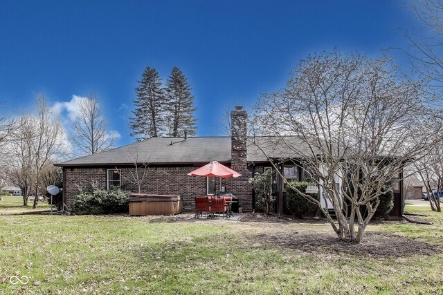 7152 Sandalwood Dr, Avon, IN 46123 - back of property with a hot tub, a patio, brick siding, a yard, and a chimney