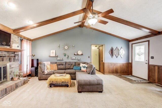 7152 Sandalwood Dr, Avon, IN 46123 - carpeted living area with a textured ceiling, a brick fireplace, ceiling fan, vaulted ceiling with beams, and wainscoting