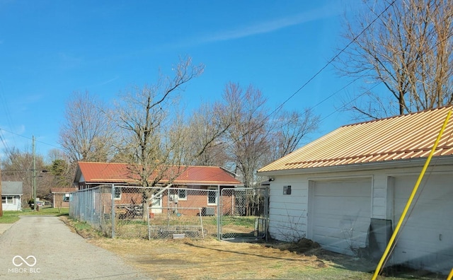 exterior space featuring a garage, metal roof, and fence