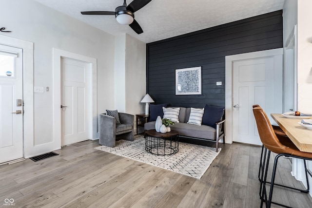 3732 N Kenwood Ave, Indianapolis, IN 46208 - living area with wood finished floors, ceiling fan, an accent wall, and wooden walls