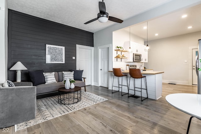 3732 N Kenwood Ave, Indianapolis, IN 46208 - living area featuring wood finished floors, ceiling fan, recessed lighting, and wood walls
