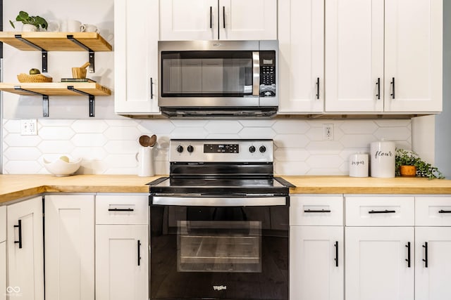 3732 N Kenwood Ave, Indianapolis, IN 46208 - kitchen with stainless steel microwave, range with electric stovetop, open shelves, wood counters, and decorative backsplash