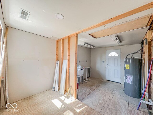 basement with visible vents and water heater