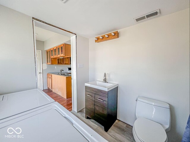 bathroom with visible vents, toilet, wood finished floors, and vanity