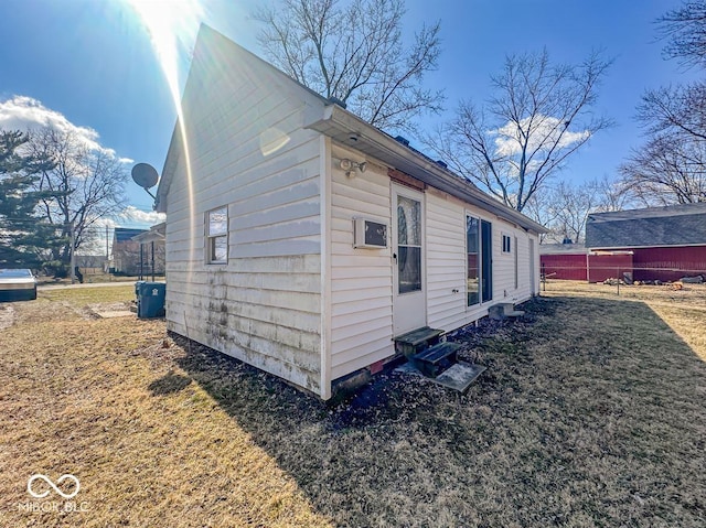 view of side of home with a lawn, entry steps, and fence