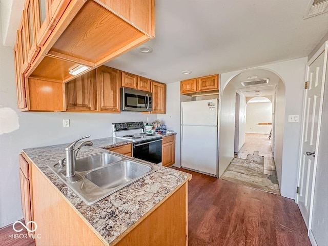 kitchen featuring visible vents, freestanding refrigerator, a sink, electric range oven, and stainless steel microwave