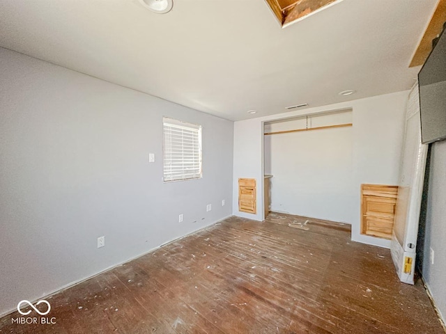 unfurnished bedroom featuring visible vents and wood finished floors