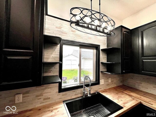 511 N Clark St, Lebanon, IN 46052 - kitchen featuring dark cabinetry, wood finished floors, open shelves, a sink, and butcher block counters
