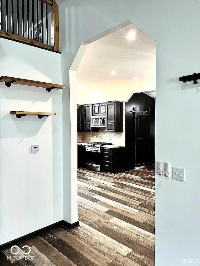 511 N Clark St, Lebanon, IN 46052 - kitchen featuring backsplash, light countertops, dark cabinetry, wood finished floors, and stainless steel appliances